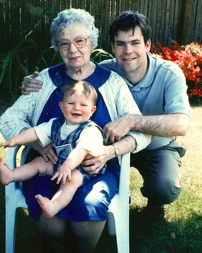 Elderly woman with family member and child outdoors.
