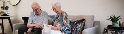 Elderly couple enjoying a conversation on a sofa.
