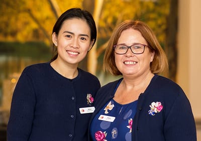 Two staff members smiling in a common area.