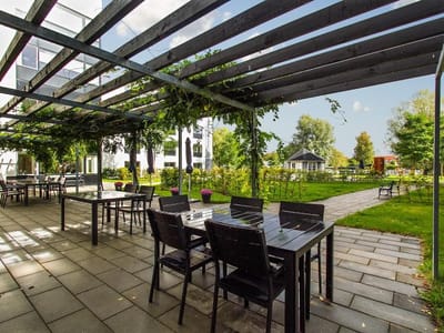 Verdishave, retirement home in Copenhagen, DK — Outdoor dining area with shaded seating and greenery