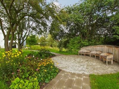 Verdishave, retirement home in Copenhagen, DK — Garden seating area surrounded by flowering plants and trees