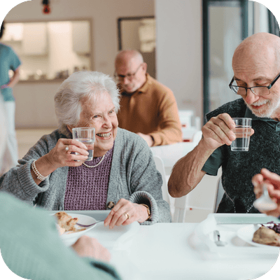 Residents enjoying a meal and drinks together.