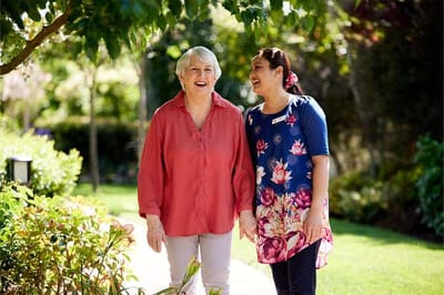 Senior resident and staff member enjoying time outdoors.
