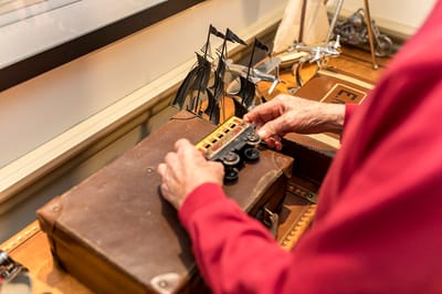 Resident interacting with model ships on a table