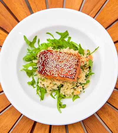 Plated meal with salmon and greens on a wooden table
