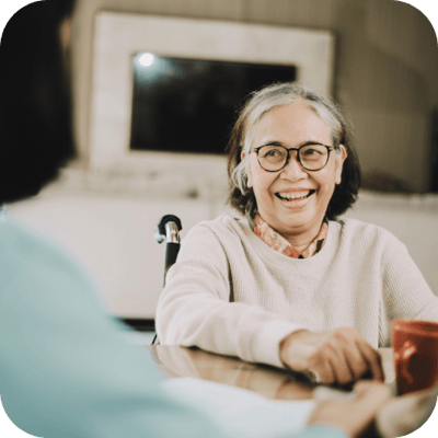 Smiling resident enjoying a conversation indoors.