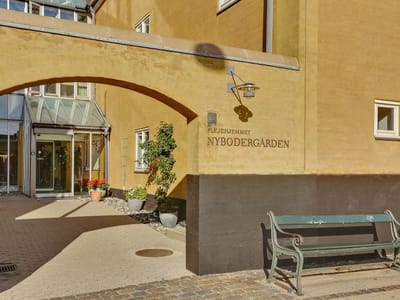 Entrance of Nybodergården with welcoming plants.