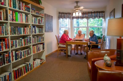 Three residents engaged around a table in a cozy setting.
