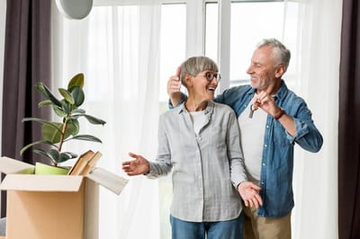 A cheerful couple celebrating in their new home.