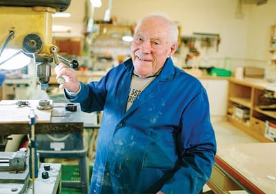 Elderly man working in a woodworking shop