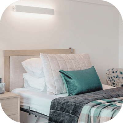 A cozy resident bedroom with bedding and decor.
