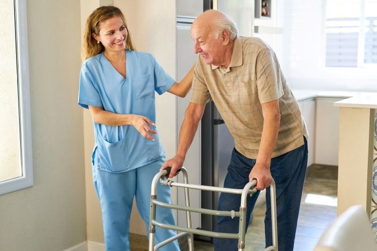 Caregiver assisting senior with walker