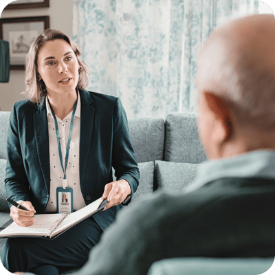 Staff member talking to a resident in a lounge
