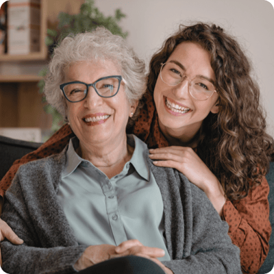 Smiling woman with elderly resident in a cozy interior