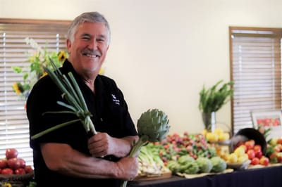 Staff member holding fresh vegetables in the common area.