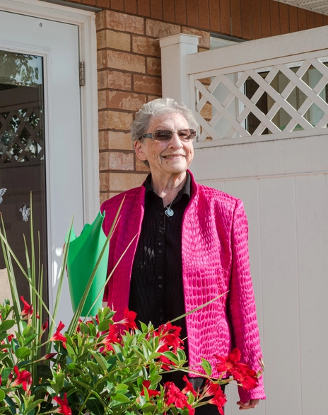 A smiling resident in a vibrant outfit with flowers