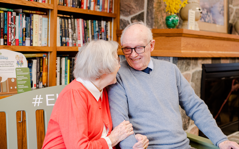 Two residents sharing a joyful moment in a cozy common area.