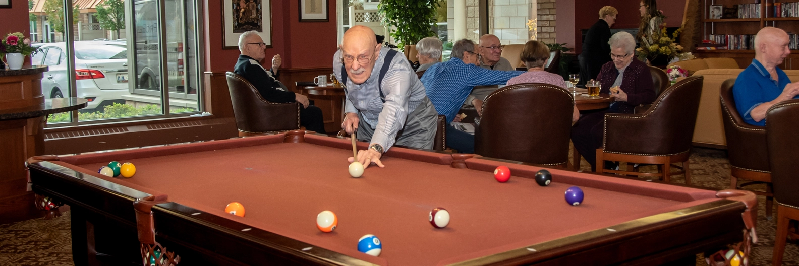 Residents enjoying a game of billiards indoors.