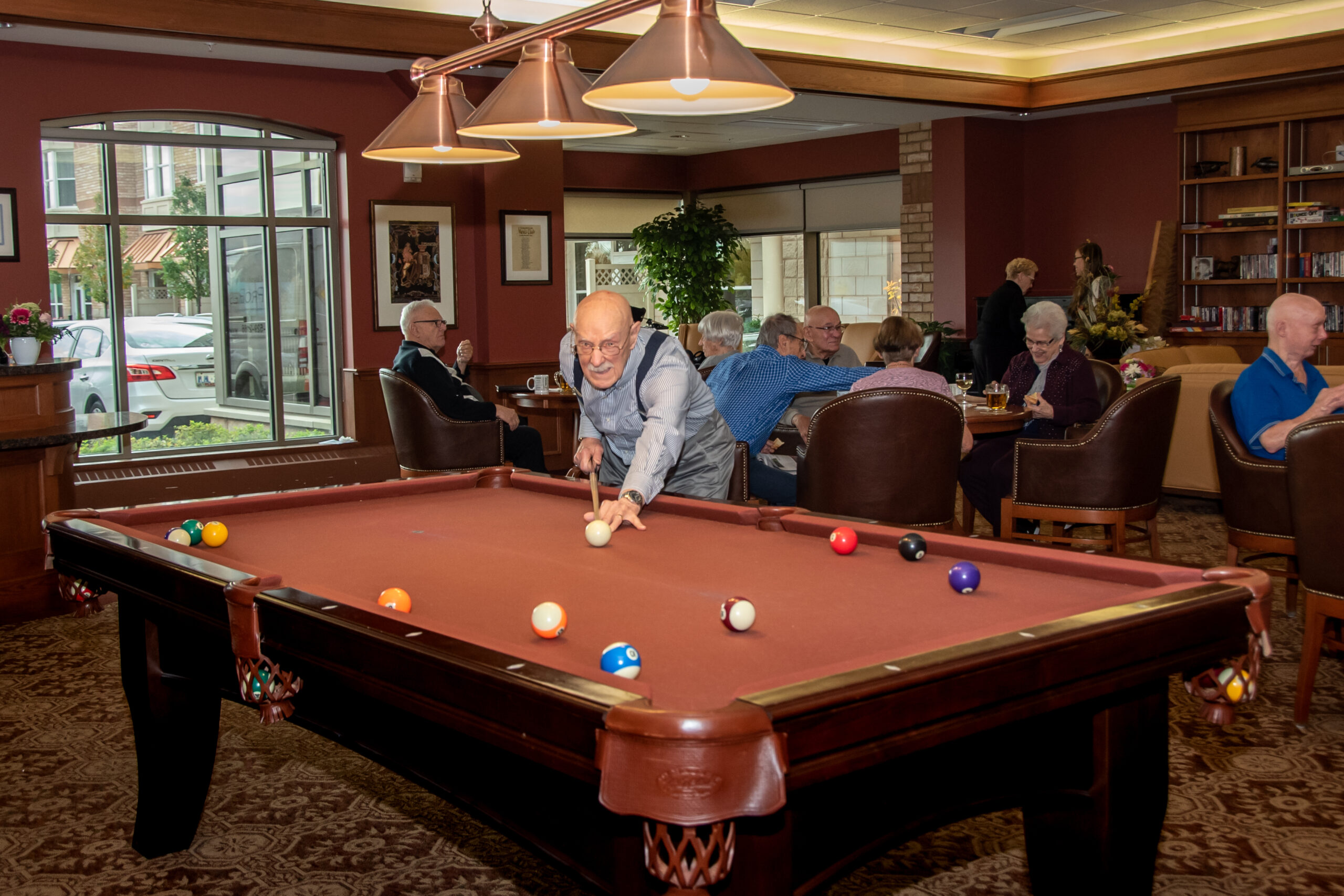 Seniors enjoying a game of billiards in the lounge.