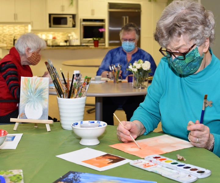Residents engaged in an art activity indoors.
