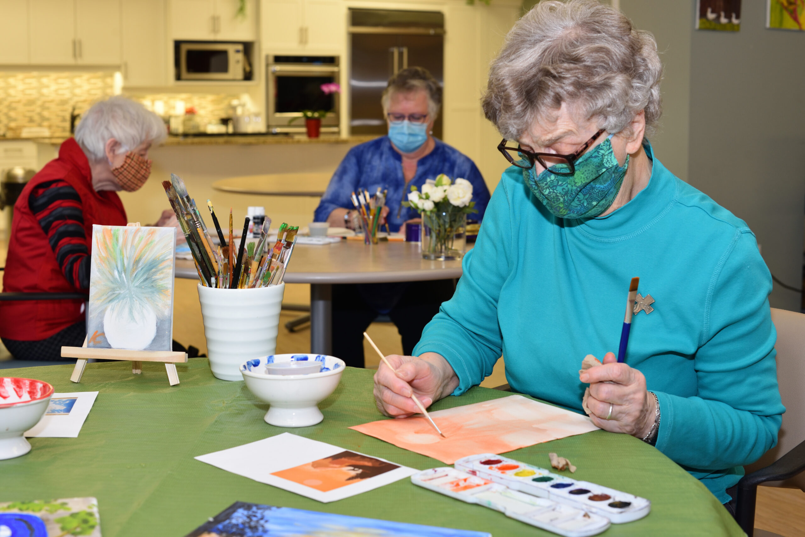 Residents engaged in an art activity inside the facility.