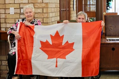 Two residents holding a Canadian flag