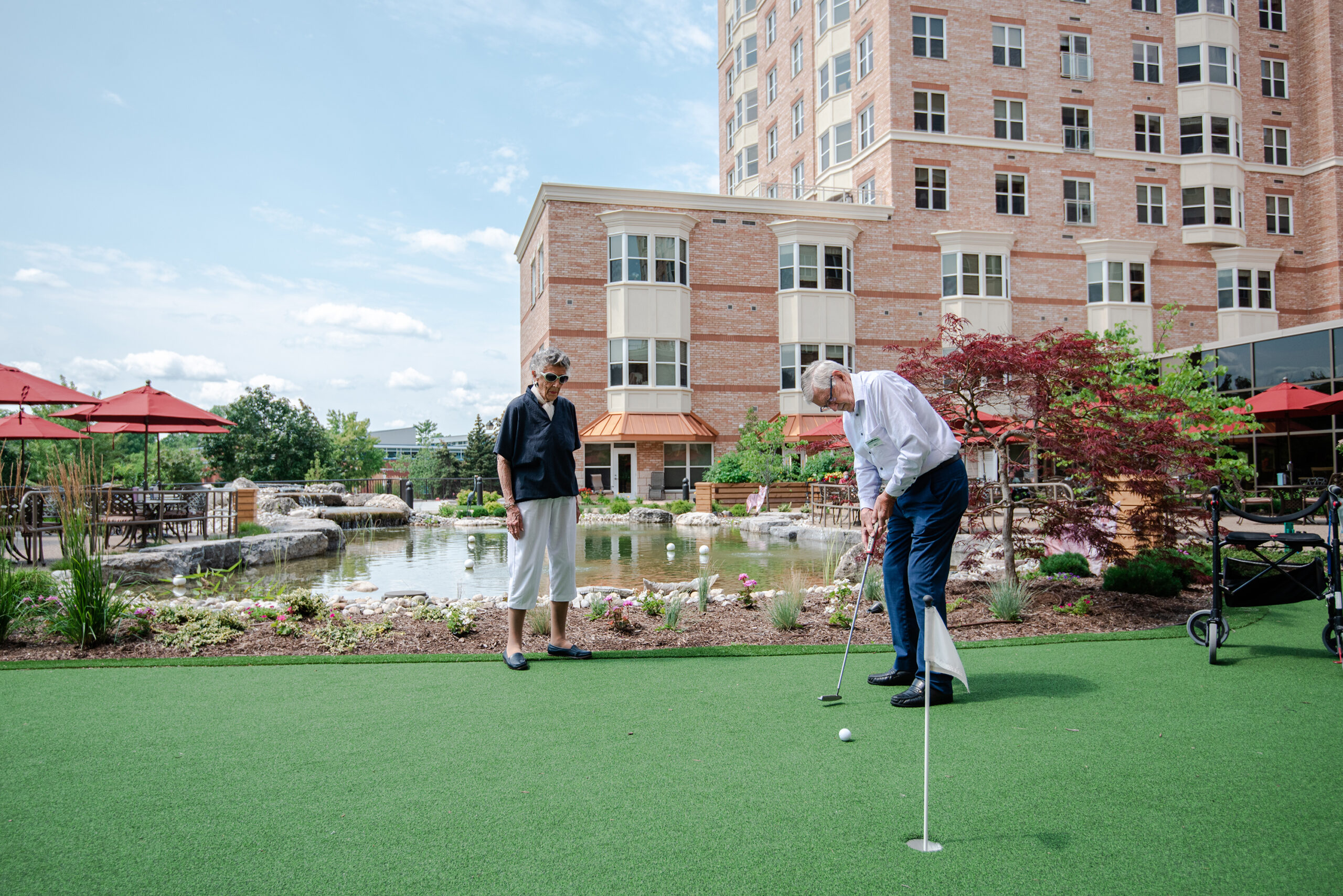Residents enjoying outdoor putting green activity.