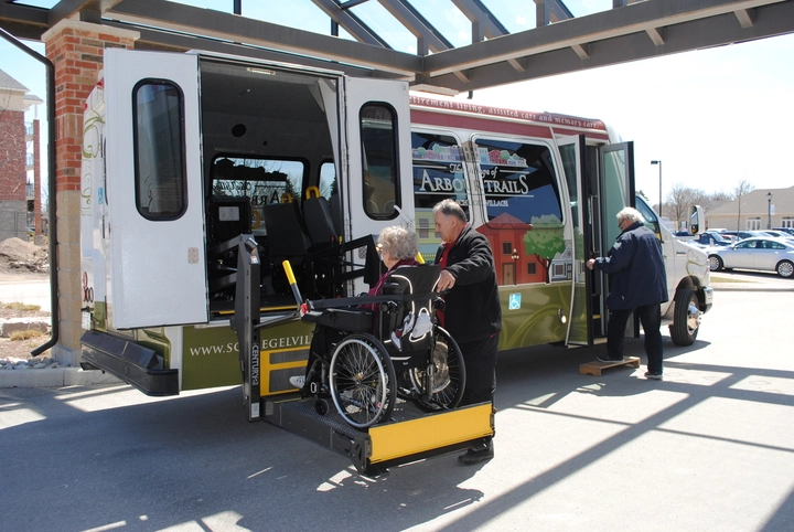 Transport vehicle assisting a resident in a wheelchair.