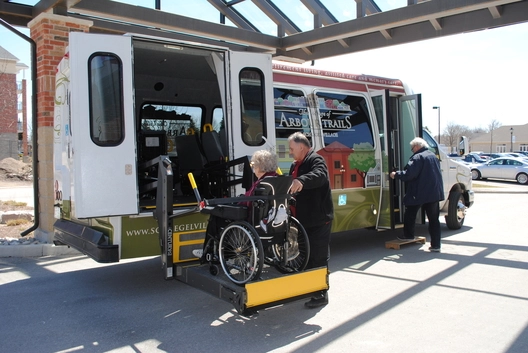 Resident using a wheelchair lift on a facility vehicle.