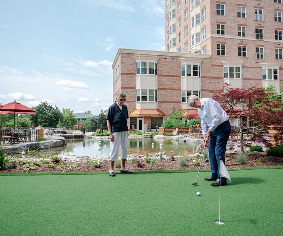 Residents enjoying a putting green outside