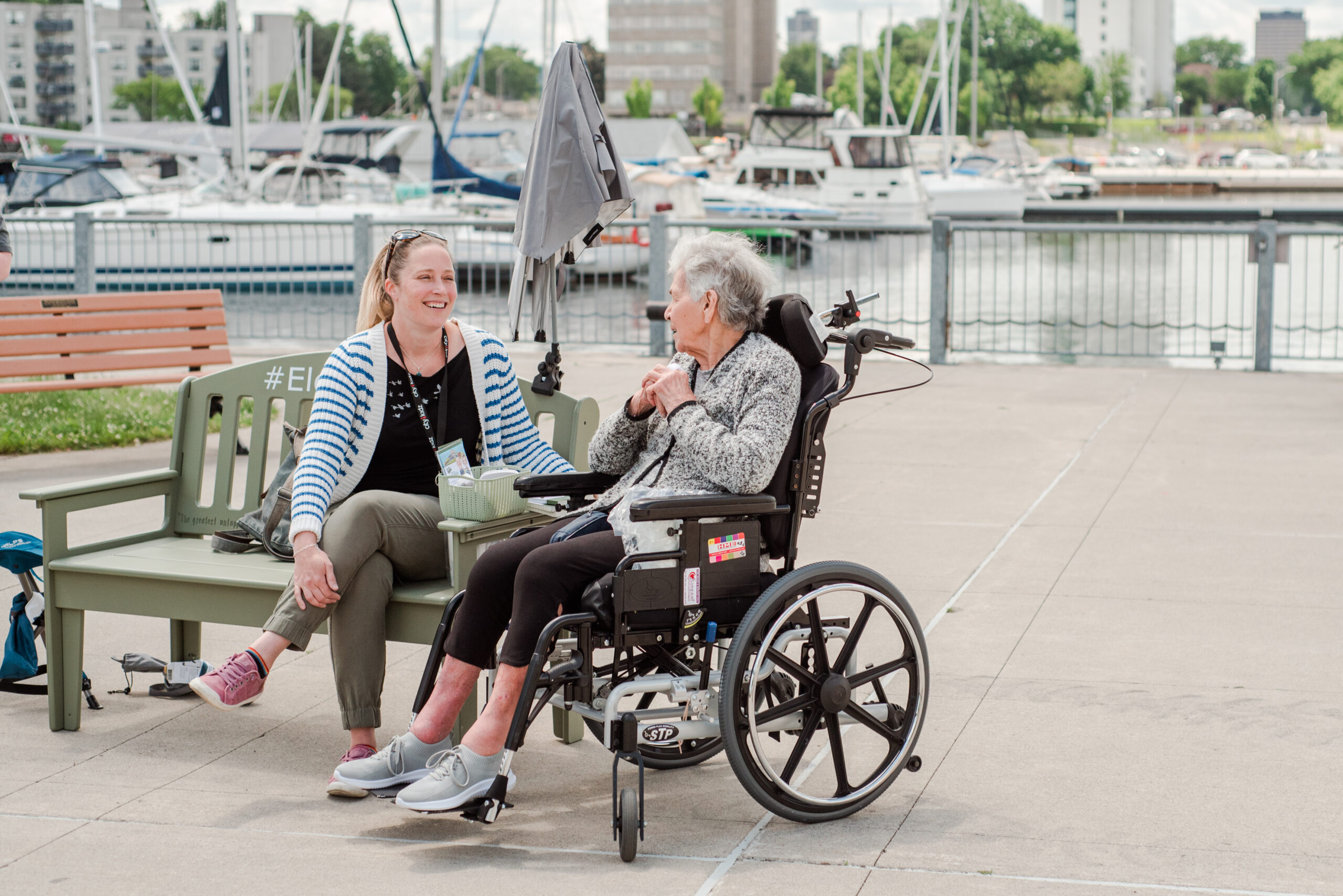 Two women enjoying a conversation outdoors by the water