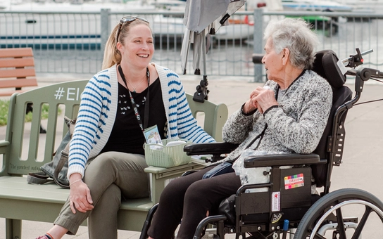 Staff member conversing with a resident outdoors