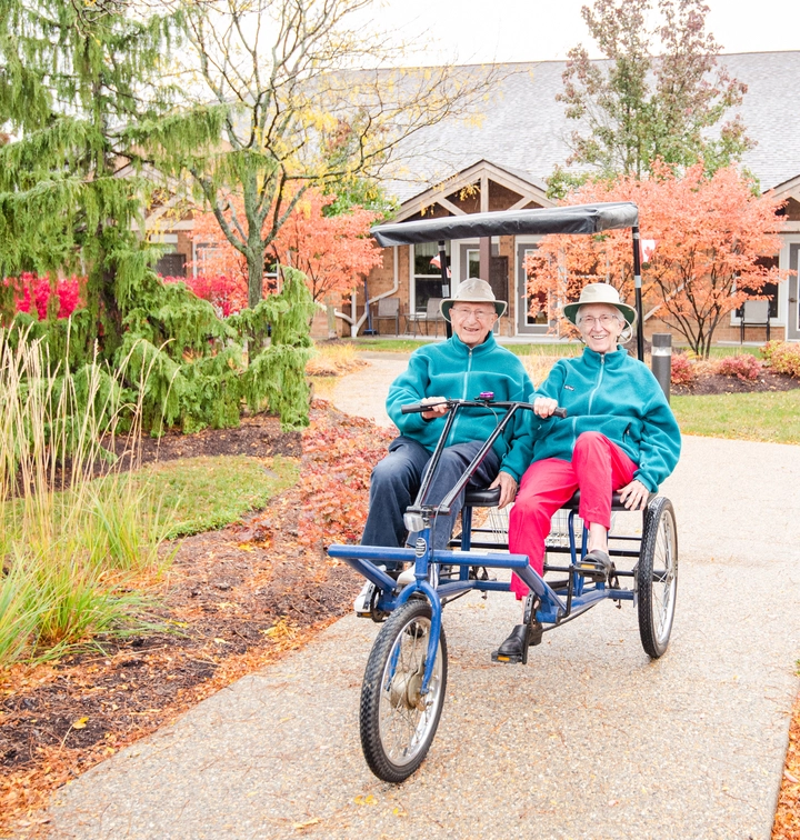 Two seniors enjoying an outdoor tricycle ride