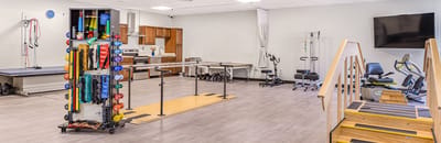 Rehabilitation gym with exercise equipment and therapy area