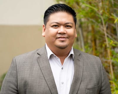 A man in a suit posing outdoors