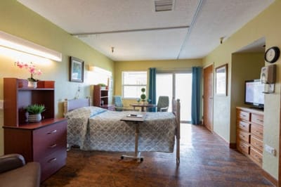 Brightly lit resident room with a bed and furnishings