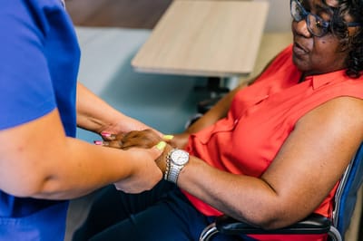 Caregiver assisting a resident with hand holding