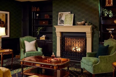 Cozy lounge area with green chairs and a fireplace