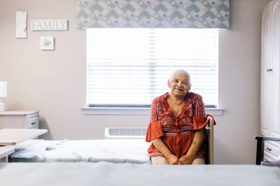 Resident sitting in a well-lit room with family decor