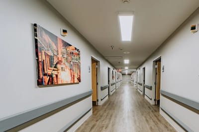 Well-lit hallway with artwork on the walls