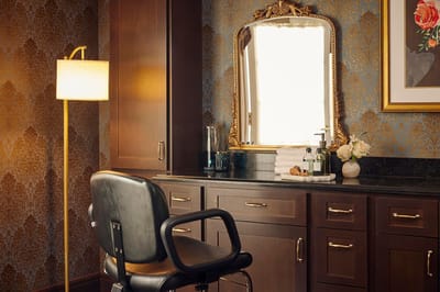 A well-lit hair salon area with a mirror and chair