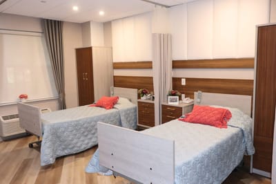 Two twin beds in a well-lit shared room