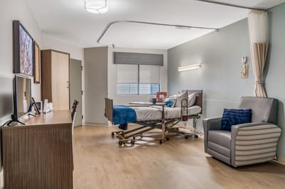 Bright interior of a resident room with hospital bed