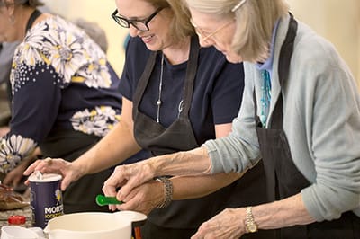 Residents and staff engaged in cooking activity