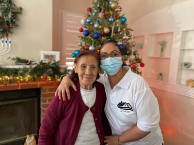 A staff member with a resident in a festive setting