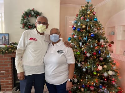 Staff members posing by a decorated Christmas tree