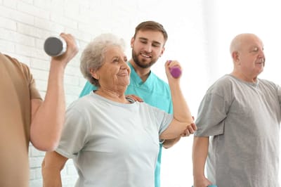 Residents participating in a group exercise activity with staff