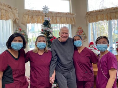 Staff and a resident celebrating the holidays indoors