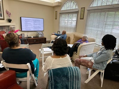 Residents and staff engaged in a group discussion in a common area