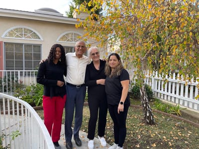 Four staff members posing outside near the facility